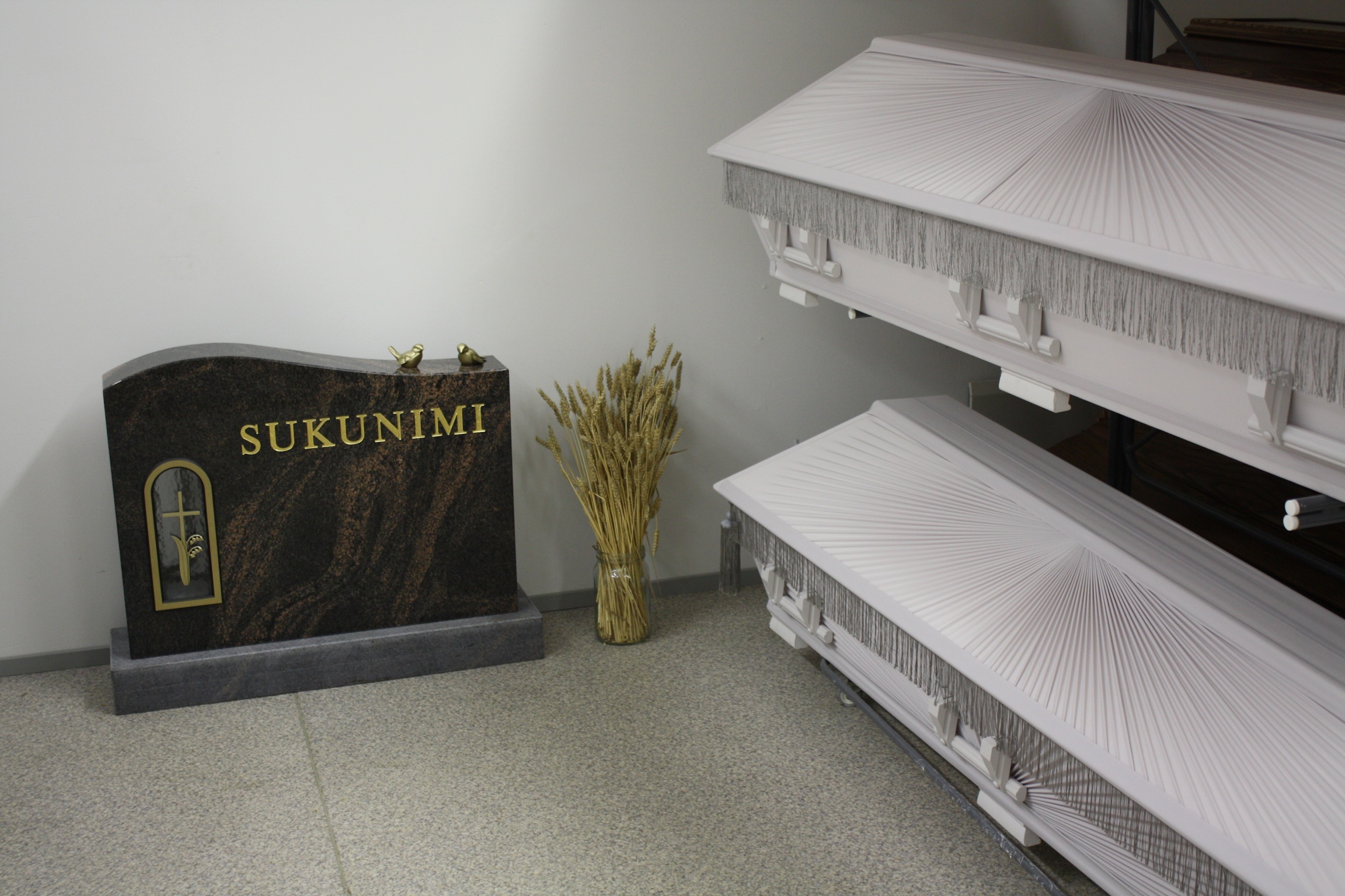 Arkkuja ja hautamuistomerkki esittelytilassa